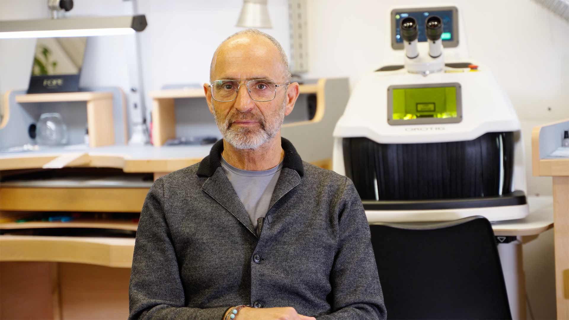 Photo of Aldo Amighini, owner of G&amp;G Amighini Jewelry in Verona; in the background, the jewelry workshop and Orotig Evo X laser welder