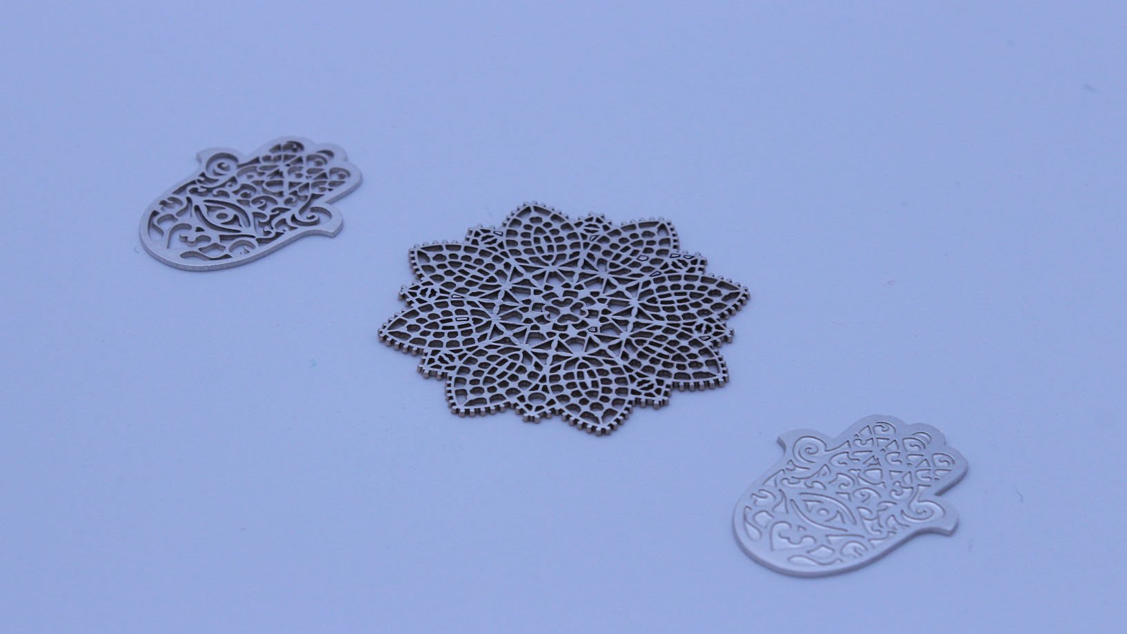 Charms with precision laser marking and cutting: Hamsa hands and flower pendant