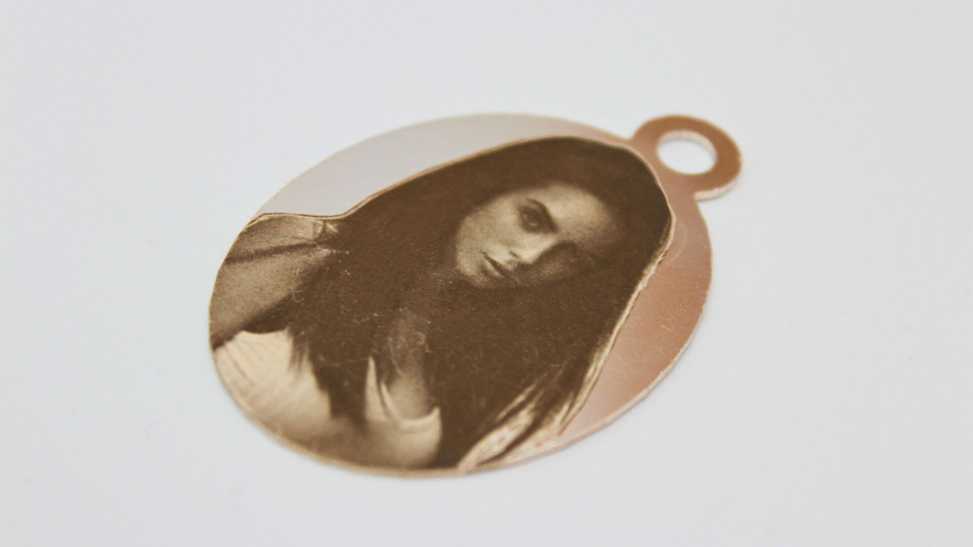 Pendant with laser photo engraving depicting a woman's portrait
