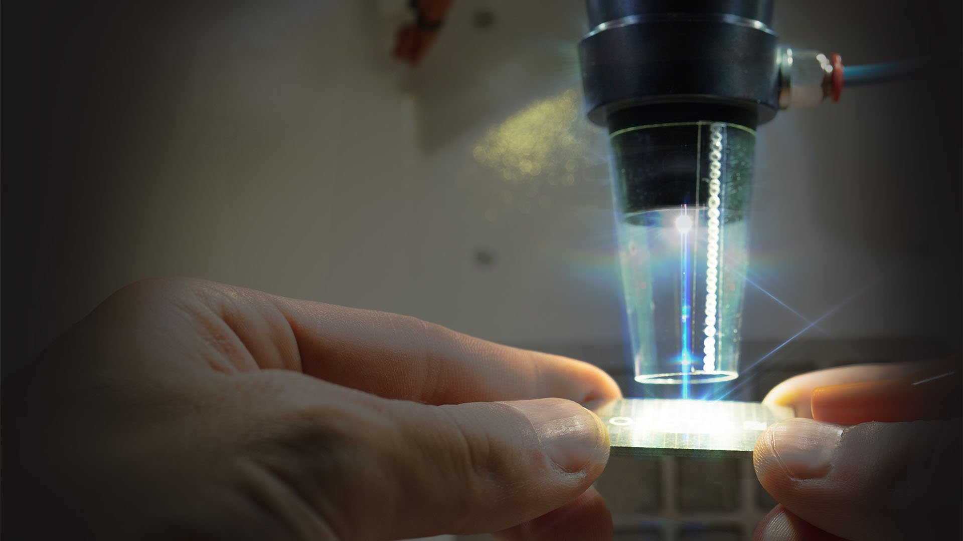 Dettaglio della camera di saldatura con il fascio laser visibile sopra una piastrina